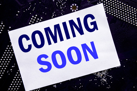 Handwritten text showing Coming Soon. Business concept for Message Future Written on sticky, computer main board background.の写真素材