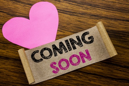 Writing text showing Coming Soon. Business concept for Message Future written on sticky note paper, wooden background. With pink heart meaning love adoration.の写真素材