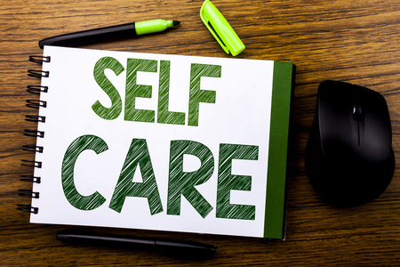 Handwriting Announcement text showing Self Care. Business concept for Taking caring for own Health written on notebook book note paper on wooden background. Green word letters. Next to mouse.の写真素材