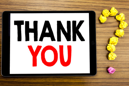 Writing text showing Thank You. Business concept for Gratitude Thanks written on tablet computer on wooden background with question mark made of folded paper.の写真素材