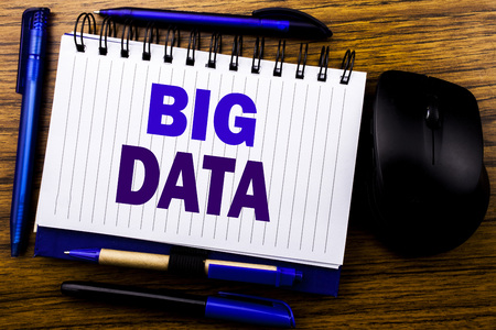 Handwritten text showing Big Data. Business concept for Digital Business Analysis written on notebook book note paper on wooden background. Blue word letters. Next to mouse.の写真素材