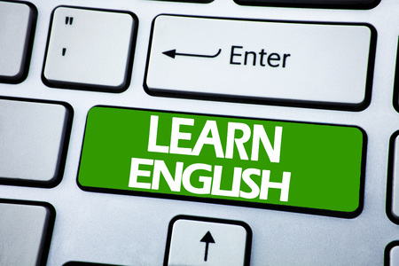 Handwriting Announcement text showing Learn English. Business concept for Language School written on blue key the keybord background.の写真素材