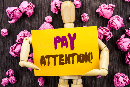 Word, writing, text  Pay Attention. Conceptual photo Be Careful Beware Mindful Alarm written Sticky Note Holding By Sculpture the wooden background.の写真素材