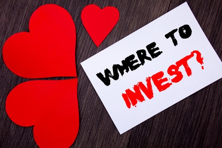 Writing text showing Where To Invest Question. Concept meaning Financial Income Investing Plan Advice Wealth written on notobook paper note on wooden background with Love Heart.の写真素材
