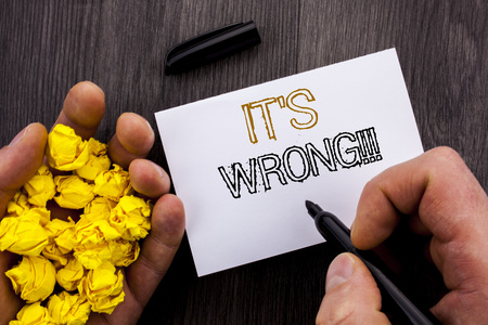 Conceptual text showing It Is Wrong. Business photo showcasing Correct Right Decision To Make Or Mistake Advice written Notebook Book Man Writing Holding Pen wooden backgroundの写真素材