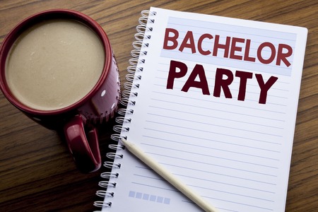 Hand writing text caption inspiration showing Bachelor Party. Business concept for Stag Fun Celebrate written on note paper notepad on the wooden background with coffee and pen.の写真素材