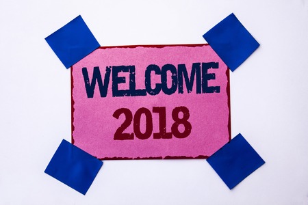 Conceptual hand writing showing Welcome 2018. Business photo text Celebration New Celebrate Future Wishes Gratifying Wish written Pink Sticky Note Paper the plain background.の写真素材