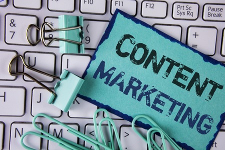 Handwriting text Content Marketing. Concept meaning Digital marketing strategy files sharing of online content written Sticky Note paper placed White Keyboard Clips and Paper Pins next to it.の写真素材