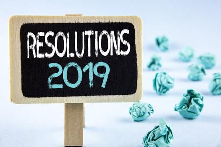 Writing note showing  Resolutions 2019. Business photo showcasing Positive reinforcement personal improvent corporate goals written Wooden Notice Board plain background Paper Balls next to it.の写真素材