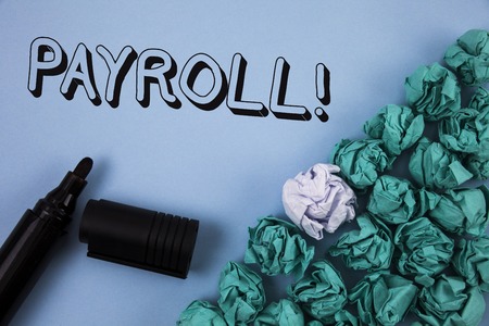 Handwriting text Payroll Motivational Call. Concept meaning Total salaries paid by a company to its employees written Plain Blue background Crumpled Paper Balls and Marker next to it.の写真素材
