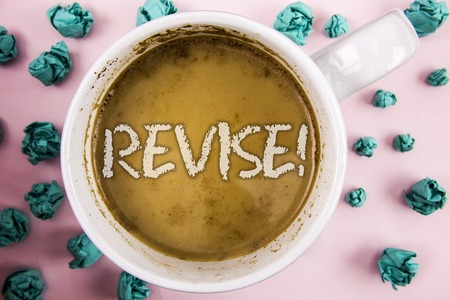 Handwriting text Revise Motivational Call. Concept meaning Reconsider something to improve it Review written Coffee in White Cup within Crumpled Paper Balls plain pink background.の写真素材