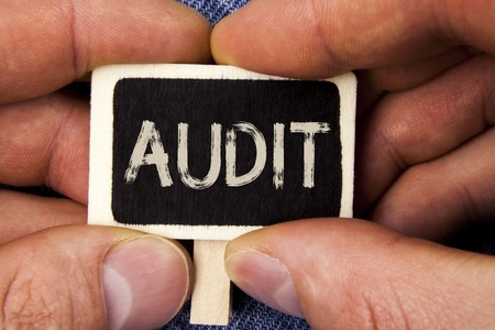 Writing note showing  Audit. Business photo showcasing Local company auditors perform their financial investigation annually written Wood Piece holding by man the Blue Jeans background.の写真素材