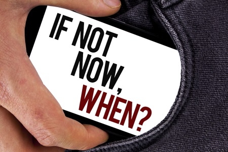 Handwriting text If Not Now When Question. Concept meaning asking about time Putting plan To do list written Mobile Screen holding in the Hand Jeans background.の写真素材