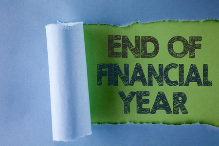 Conceptual hand writing showing End Of Financial Year. Business photo text Taxes time accounting June database cost Sheets written under Tear Folded paper plain Green background.の写真素材