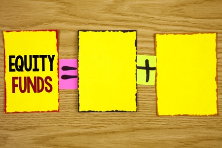 Handwriting text writing Equity Funds. Concept meaning Investors enjoys great benefits with long term investment written Sticky Note Paper wooden background. Equation with Plus sign.の写真素材
