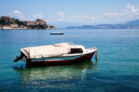 Boat trip along river in Corfu Greece. Ship on clean blue water. Island houses on the shore view. Greek beautiful landscape. White boats sailing. Relaxation, travelingの写真素材