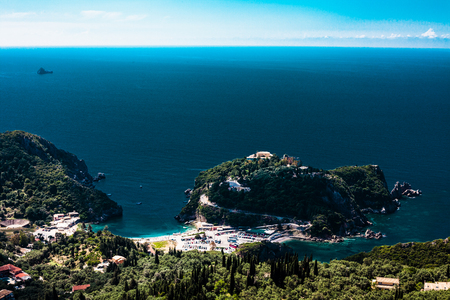 Island aerial view blue ocean behind. Beautiful Greek landscape. Corfu Greece natural places. Mountain next to sea water. Gorgeous place. Traveling to other countriesの写真素材