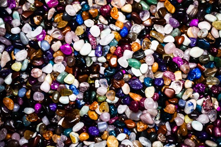 Group of many different natural gemstones. Collection of small colored semiprecious gemstones amethyst, lapis lazuli, rose quartz, citrine, ruby, amazonite, moonstone, labradorite, chalcedonyの写真素材