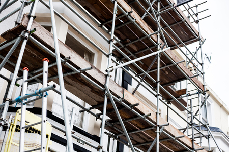 Construction and repair building on the street with metal protection. Restoring and repairing building facade. Building under repair and construction.の写真素材