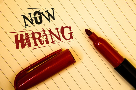 Text sign showing Now Hiring. Conceptual photo Workforce Wanted Employees Recruitment Today Job OpportunityIdeas messages created on notebook page black red letters open pen restingの写真素材