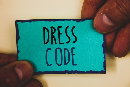 Words writing texts Dress Code. Business concept for Rules of what you can wear and not to school or an eventMan hold holding turquoise note black letters and frame beige backgroundの写真素材