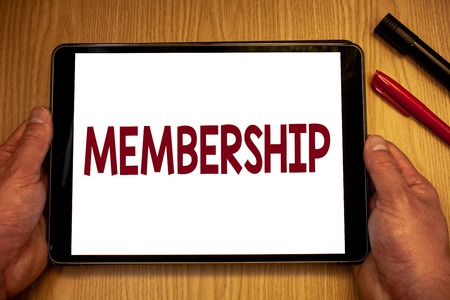 Text sign showing Membership. Conceptual photo Being member Part of a group or team Join an organizationMan hold holding table with ideas words white screen black red pens woodenの写真素材