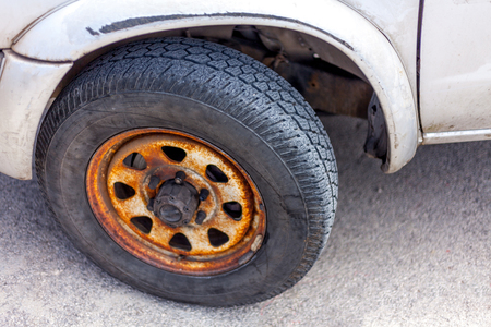 Rust covering the entire rim of a car. Depth scratches stretching in the vehicle guard.Slanting parking position. Maintenance and repair of a ground transportationの写真素材
