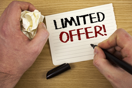 Handwriting text Limited Offer Motivational Call. Concept meaning Short time special clearance Price Reduction Text two words white paper note black marker hand crumbled paper noteの写真素材