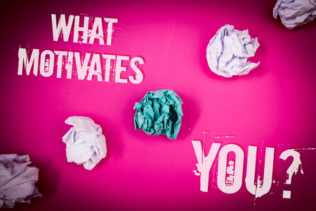 Handwriting text What Motivates You Question. Concept meaning Passion Drive Incentive Dream Aspiration Light pink floor circled shadow ruffled white paper balls middle green ballの写真素材