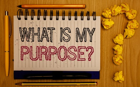 Text sign showing What Is My Purpose Question. Conceptual photo Direction Importance Discernment Reflection Notepad with outline text pen pencil woody desk crimp balls form query markの写真素材