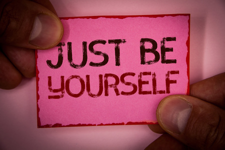 Handwriting text Just Be Yourself. Concept meaning Self Attitude Confidence True Confident Honesty Motivation Words written pink paper note red border fingers holding corners messageの写真素材