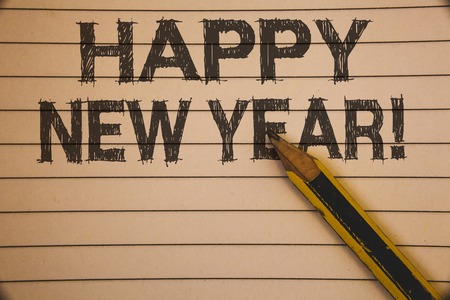 Writing note showing  Happy New Year Motivational Call. Business photo showcasing Greeting Celebrating Holiday Fresh Start Ideas concepts on old beige notebook paper pen resting black lettersの写真素材