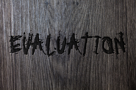 Word writing text Evaluation. Business concept for Judgment Feedback Evaluate the quality performance of something Wooden wood background black engraved letters words ideas messages conceptsの写真素材