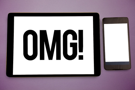 Writing note showing Omg Motivational Call. Business photo showcasing Oh my good abbreviation Modern Astonishment expression Wide framed white smart screen tablet text messages communicate ideaの写真素材