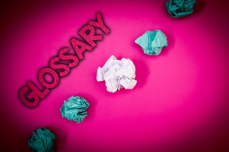 Conceptual hand writing showing Glossary. Business photo text Alphabetical list of terms with meanings Vocabulary Descriptions Ideas messages pink background crumpled papers several triesの写真素材