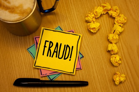 Writing note showing  Fraud Motivational Call. Business photo showcasing Criminal deception to get financial or personal gain Message wood table coffee cup question mark crumpled papersの写真素材
