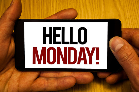 Text sign showing Hello Monday Motivational Call. Conceptual photo Positive Message for a new day Week Start Two hands holding black phone screen words written home button pressの写真素材