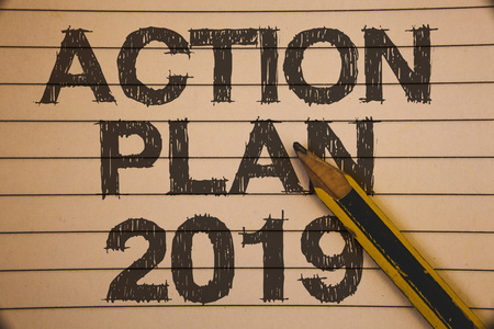 Writing note showing  Action Plan 2019. Business photo showcasing Challenge Ideas Goals for New Year Motivation to Start Ideas concepts on old beige notebook paper pen resting black lettersの写真素材