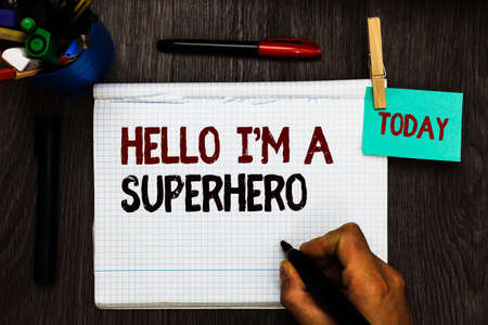 Conceptual hand writing showing Hello I am A Superhero. Business photo text Believing in yourself Self-confidence Introduction Register pages handwriting text work stationery items woody tableの写真素材
