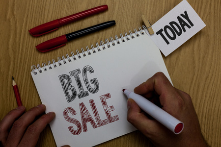 Conceptual hand writing showing Big Sale. Business photo showcasing putting products on high discount Great price Black Friday Man holding marker notebook reminder wooden table cup coffeeの写真素材