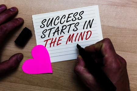 Handwriting text writing Success Starts In The Mind. Concept meaning Have positive thoughts accomplish what you want Written on notepad hand hold marker with love heart wooden backgroundの写真素材