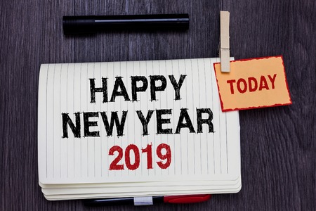 Handwriting text writing Happy New Year 2019. Concept meaning Greeting Celebrating Holiday Fresh Start Best wishes Written paper on wooden desk paper clip grip note with red words black penの写真素材