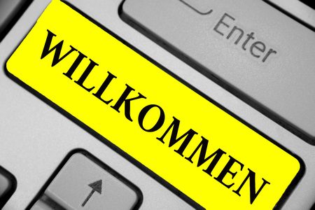 Writing note showing Willkommen. Business photo showcasing welcoming people event or your home something to that effect Keyboard yellow key Intention computer computing reflection documentの写真素材