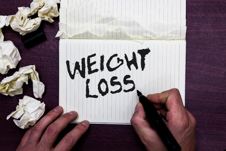 Word writing text Weight Loss. Business concept for Decrease in Body Fluid Muscle Mass Reduce Fat Dispose Tissue Man holding marker notebook page crumpled papers several tries mistakesの写真素材