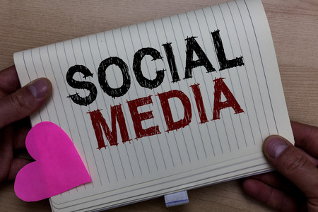 Word writing text Social Media. Business concept for Online communication channel Networking Microblogging Man holding notebook paper heart Romantic ideas messages Wooden backgroundの写真素材