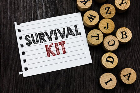 Word writing text Survival Kit. Business concept for Emergency Equipment Collection of items to help someone Piece notebook paper circle letters ideas inspiration wooden backgroundの写真素材