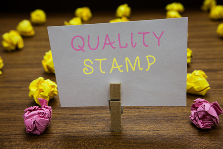 Handwriting text writing Quality Stamp. Concept meaning Seal of Approval Good Impression Qualified Passed Inspection Clothespin holding white paper note crumpled papers several tries mistakesの写真素材