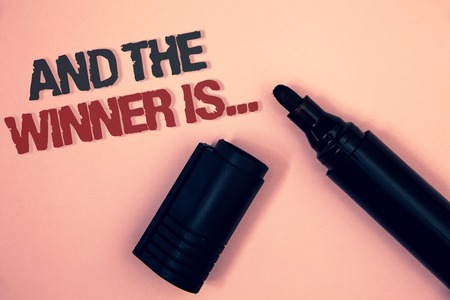 Text sign showing And The Winner Is . Conceptual photo Announcing as first place in competition or race Pinkish platform black and red message one corner open black markerの写真素材