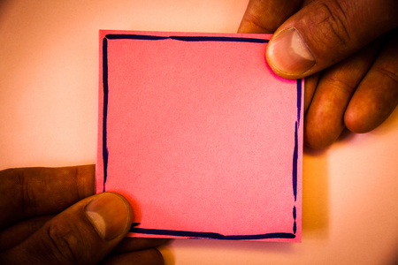 Man holding a pink paper for messagesの写真素材