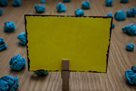 Business concept Empty template copy space isolated Posters coupons promotional material. Clothespin holding yellow paper note crumpled papers several tries mistakesの写真素材